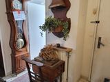 une petite table sur laquelle se trouve une horloge, dans un coin de la pièce