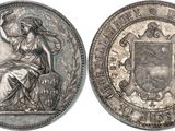 a silver coin with a woman sitting on top of it