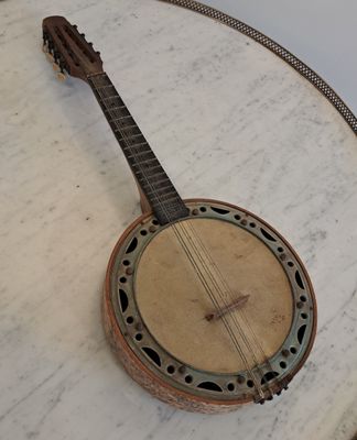 un banjo posé sur une table en marbre, entouré d'une chaîne