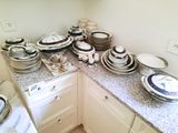 many plates and bowls on the counter in the kitchen