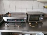 two microwaves sitting on a counter in a kitchen