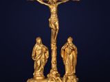 a gold statue of jesus on the cross with other figures