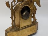 a gold clock with an angel on top of it