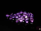 purple amethe crystals are scattered on a black surface
