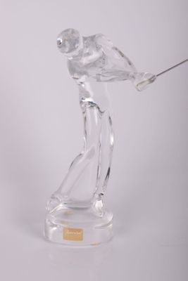 figurine en verre transparent représentant un homme tenant un club de golf, posée sur une surface transparente