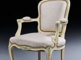 a white chair with a beige upholstered back and arms