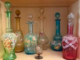 de nombreux vases en verre de différentes couleurs posés sur une étagère