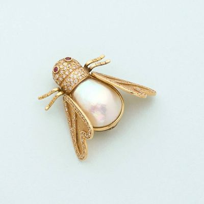 an image of a gold bee broochle with a pearl and diamonds