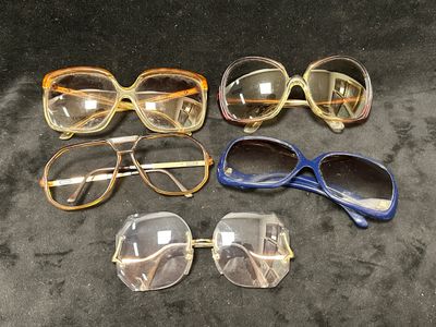 Plusieurs paires de lunettes sont alignées sur une surface noire