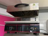 une image d'un gril électrique commercial dans une cuisine commerciale