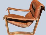a brown leather chair with a wooden frame on it