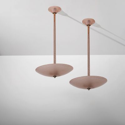une paire de lampes en verre rose suspendues au plafond