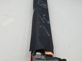 a black umbrella with a drawing on it laying on a white surface