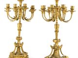paire de chandeliers anciens en laiton avec des bougies posées sur des socles