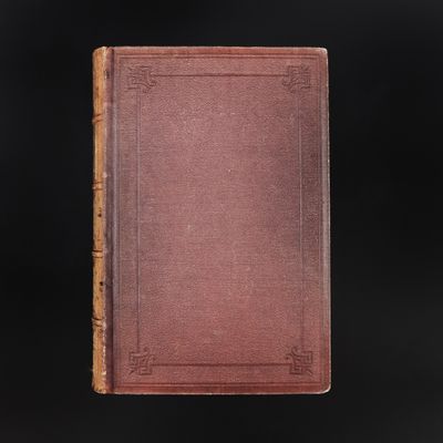 an old book with a brown cover on a black background
