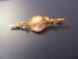 une image représentant une barrette de couleur dorée ornée d'un camée représentant une femme