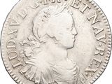 a silver coin with a woman ' s head and a crown on it
