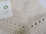 a white crocheted blanket on a white table
