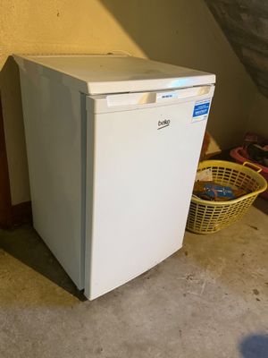 an image of a small white refrigerator in a room