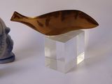two figurines sitting next to each other on a white surface