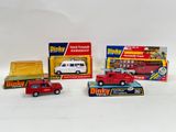 several toy cars and trucks are lined up on a white surface