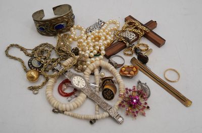 a pile of jewelry on a table with a cross