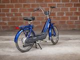 an image of a blue bike parked in front of a brick wall