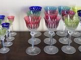 many different colored wine glasses lined up on a table