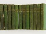 six livres verts sont empilés les uns sur les autres sur une surface blanche