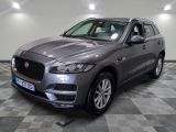 un SUV Jaguar gris garé sur un sol à damier dans un garage