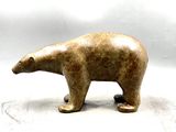 une petite statue représentant un ours polaire posée sur une surface blanche
