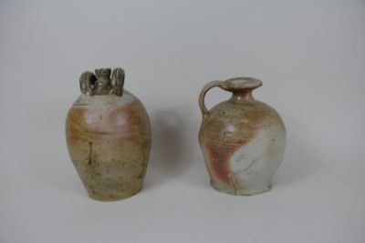deux vases posés l'un à côté de l'autre sur une surface blanche