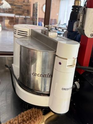 un bol de nourriture posé sur un plan de travail, à côté d'un mixeur et d'une tasse de café