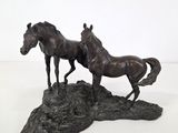 a statue of two horses standing on top of a rock
