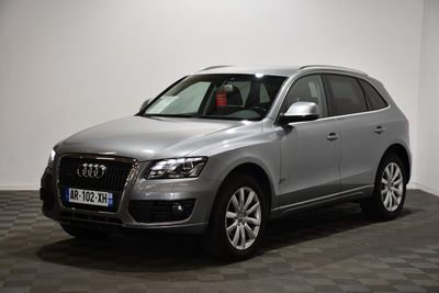 un SUV Audi argenté garé dans une pièce au sol en damier