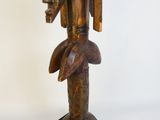 une statue en bois représentant un homme avec un oiseau sur l'épaule