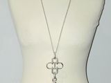 necklace with a cross and a key on a mannequin torso
