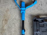 a blue scooter sitting on the ground next to a tool case