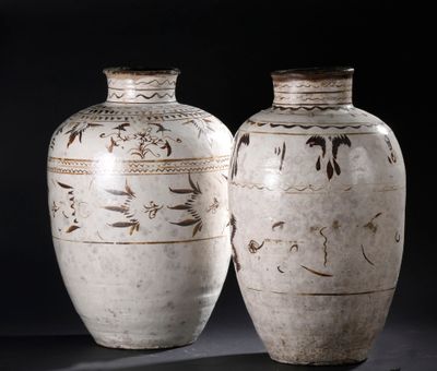 two vases sitting side by side on a black background