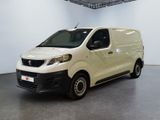 La petite camionnette blanche est garée dans une grande pièce