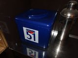 a blue container sitting on a counter next to a shaker
