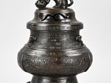 bronze urn with a dog on top of it on a pedestal