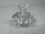 a glass bottle with a flower on it on a table