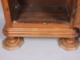 a wooden cabinet with a glass door on top of it