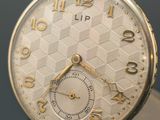 a close up of a gold pocket watch on a table