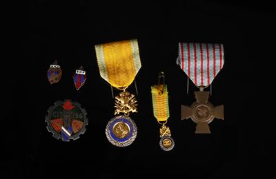 several medals are displayed on a black surface in a dark room