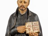figurine of a man holding a book with a quote on it