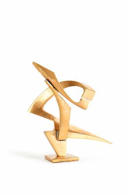 gold plated sculpture of a stylized design on a white background