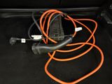 a car trunk with an orange cord and a charger attached to it