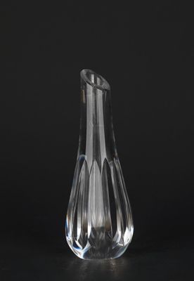 un vase en verre transparent posé sur une table devant un fond noir